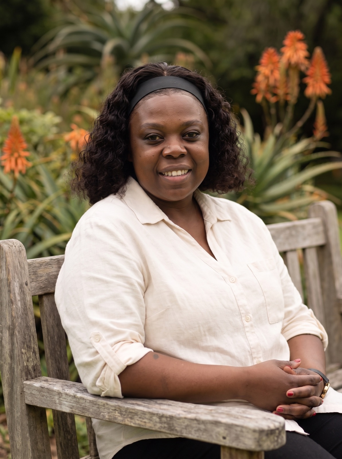 Yvonne smiling on a garden bench